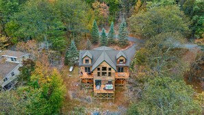 A cabin with a central deck, surrounded by dense forest. - Fam-friendly Cabin Mins 2 Beach Ski w Hot Tub (Lake Harmony)