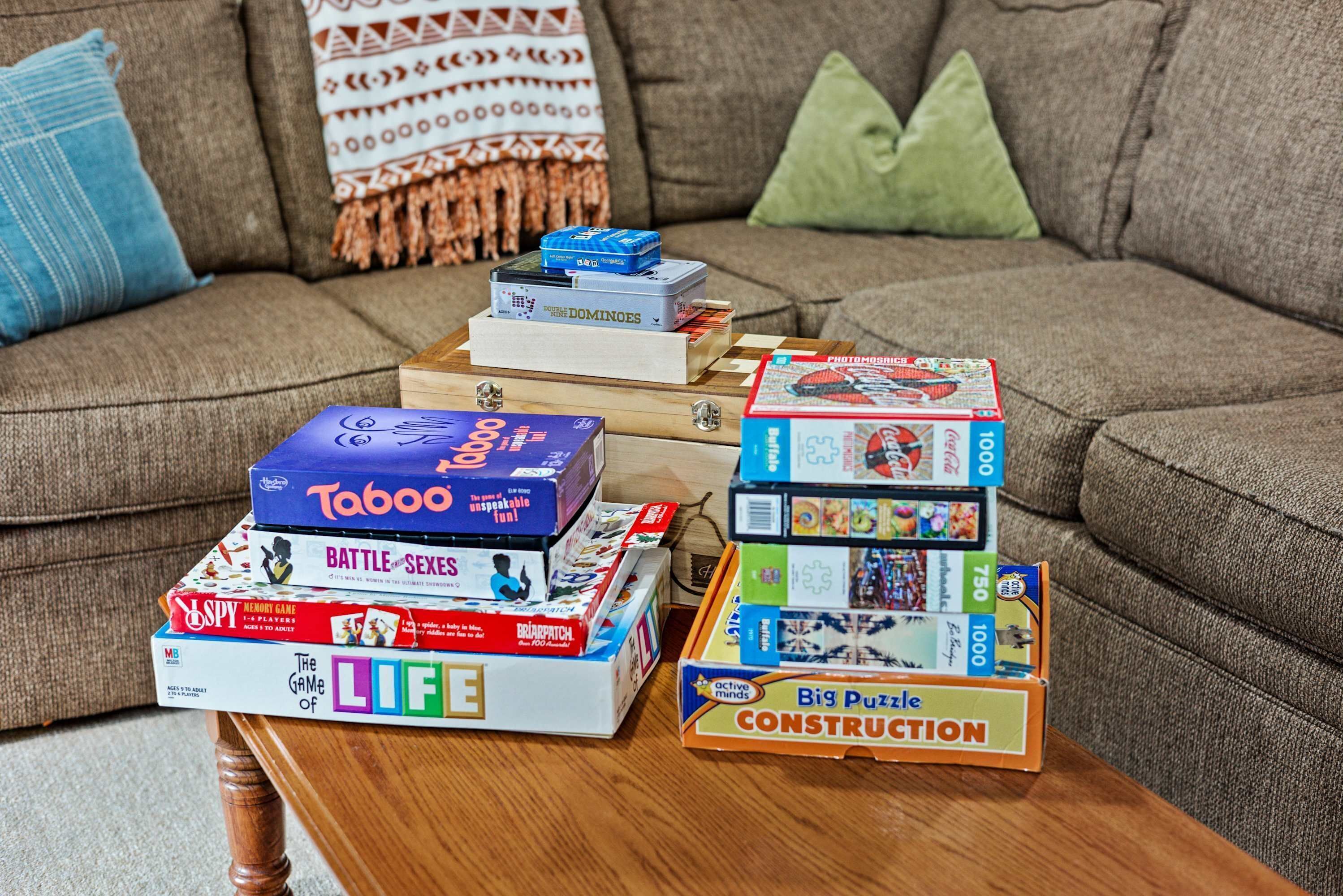 A living room with a sofa, a coffee table, and various board games.