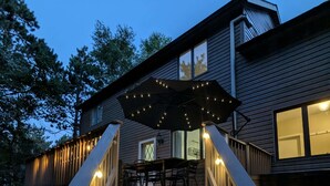 A wooden staircase leading to a deck with outdoor lighting and a table and chairs. - Indoorpool Hottub Gameroom Firepit Dogfriendly (Long Pond)
