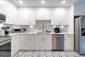 A modern kitchen with white cabinets, a stainless steel dishwasher, and a microwave. - Indoorpool Hottub Gameroom Firepit Dogfriendly (Long Pond)