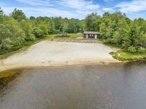 A sandy beach area with a small building, a playground, and dense greenery. - Indoorpool Hottub Gameroom Firepit Dogfriendly (Long Pond)