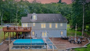 Et toetagers hus med en terrasse, swimmingpool og udendørs møbler.