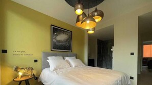 A bedroom with a bed, a nightstand, a wall-mounted lamp, and a framed picture. - Suite "Petit Prince" - 2/4 Pers (Niergnies)