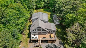 A large house with a deck, surrounded by dense forest. - Game Room A C Dog-friendly Stay With Hot Tub (Albrightsville)
