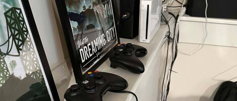 A gaming setup with a monitor, controller, and Xbox console.