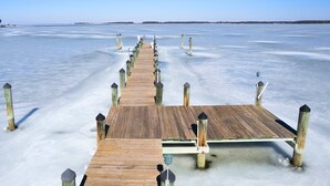 A wooden pier extending into a frozen body of water. - Modern Chesapeake Waterfront - Heated Pool - Dock (Cambridge)