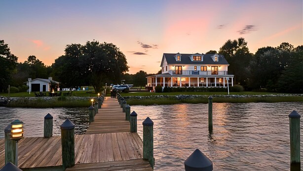 A waterfront property with a wooden dock leading to a large house. - Modern Chesapeake Waterfront - Heated Pool - Dock (Cambridge)