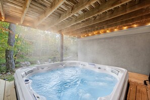 A hot tub in a covered outdoor area with a wooden ceiling and a view of trees. - Streamside Hot Tub Dog Friendly Resort Access (Pocono Lake)