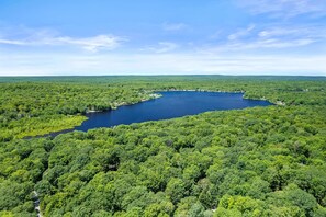 A lake surrounded by dense forest. - Streamside Hot Tub Dog Friendly Resort Access (Pocono Lake)