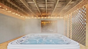 A hot tub in a wooden cabin with a lattice window and string lights. - Streamside Hot Tub Dog Friendly Resort Access (Pocono Lake)