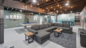 A modern living room with a sectional sofa, a pool table, and a dartboard. - Amenity-filled Retreat by Jfbb-pickleball-gameroom (Albrightsville)