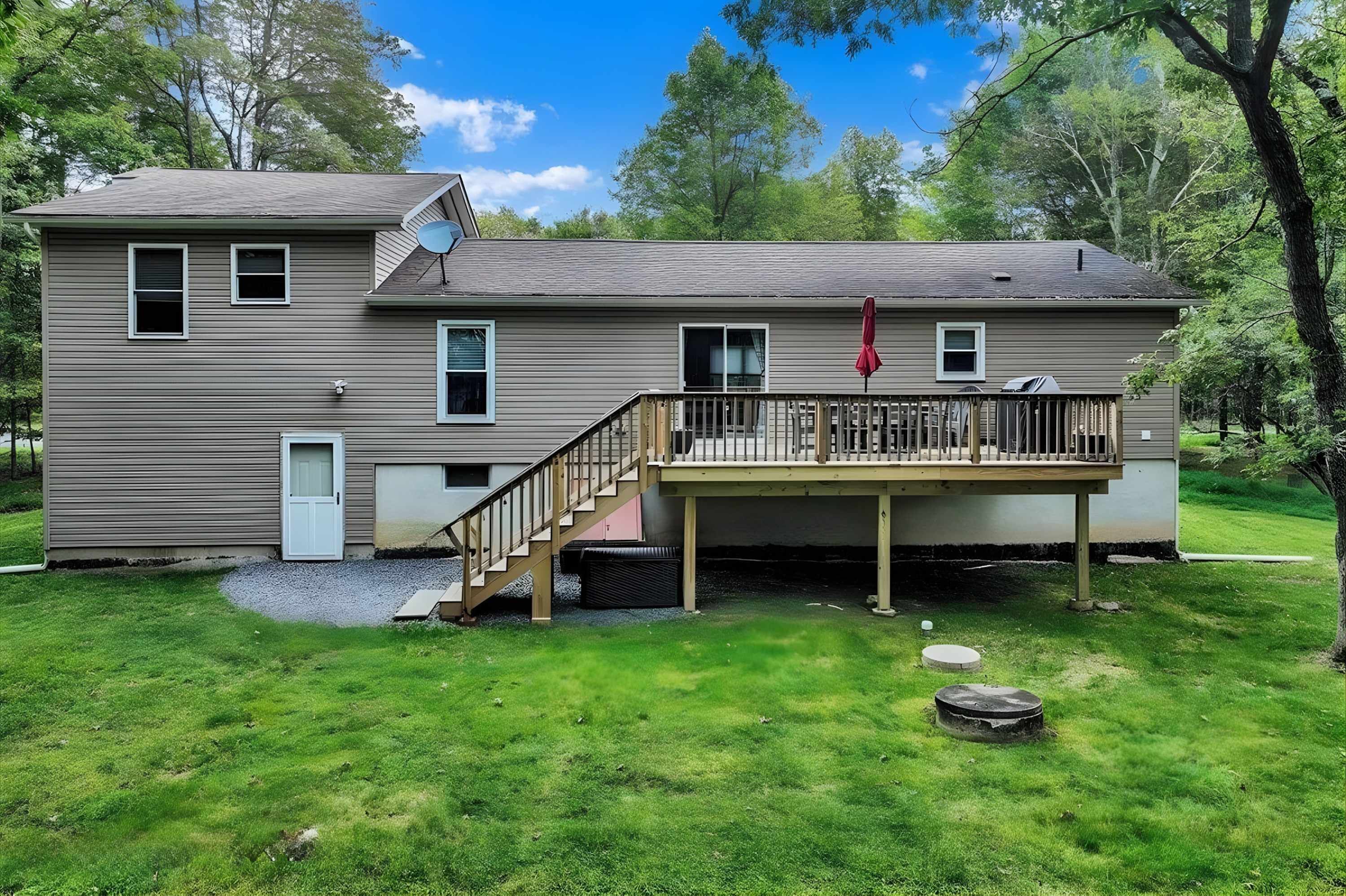 A two-story house with a deck, a satellite dish, and a garage.