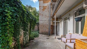 Une ruelle étroite, avec un mur de briques d’un côté et un banc en bois de l’autre.