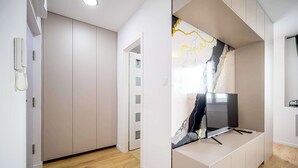 A modern room with a built-in TV, wooden flooring, and a decorative wall.