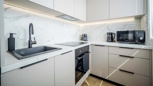 A modern kitchen with a built-in sink, a microwave, and an oven.