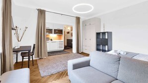 Een moderne woonkamer met een bank, een eettafel en een keuken op de achtergrond.