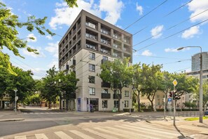 A multi-story building with balconies, a pedestrian crossing, and street signs. - Urban White Oasis in Centre (Bratislava - Old Town)