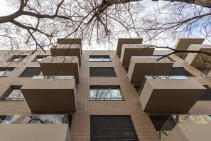 Ein mehrgeschossiges Gebäude mit moderner Architektur, mit rechteckigen Fenstern und Balkonen.