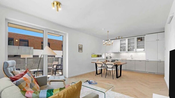 Een modern appartement met een zithoek, eetgedeelte en keuken.