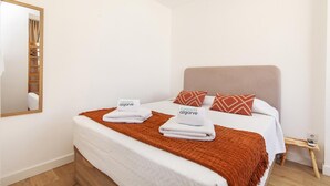 A neatly made bed with two pillows, a wooden bedside table, and a mirror on the wall. - B93 - Miralvor 2 Bed Apartment in Alvor (Alvor)