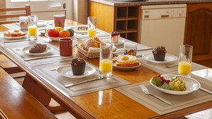 Una mesa de desayuno con diversos platos, como tostadas, huevos, muffins y fruta.