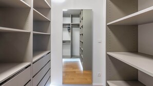 Un pasillo estrecho con estanterías blancas a ambos lados y suelo de madera.