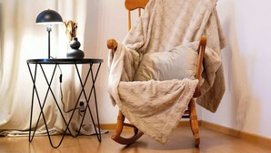 A rocking chair with a blanket, a lamp, and a vase with dried flowers on a small table. - Your City Center Stylish & Spacious Apartment (Košice)