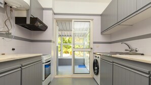 A compact kitchen with a built-in oven, a washing machine, and a sink. - A72 - Praia da Luz Coast Flat (Praia da Luz)