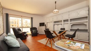 A living room with a sofa, chairs, a glass table, and a magazine. - A72 - Praia da Luz Coast Flat (Praia da Luz)
