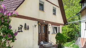 Ein Gebäude mit Holztür, einer kleinen Veranda und einem Schild mit Elch und Baum.
