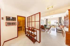 Ein Hotelzimmer mit traditioneller japanischer Schiebetür, einem Essbereich mit einem grünen Tisch und Blick auf die Stadt.