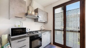 A kitchen with a microwave, stove, oven, and cabinets.