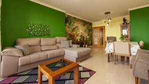 A living room with a sofa, coffee table, and a dining area with chairs and a table. - C08 - Ladeira do Convento 3 Bed Apartment in Lagos (Lagos)