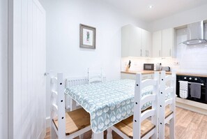Una cocina moderna con armarios blancos, un microondas y una estufa.