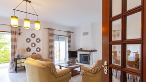 A living room with two sofas, a TV, a fireplace, and a large window. - B102 -  Sol Sol Lagos Apartment (Lagos)