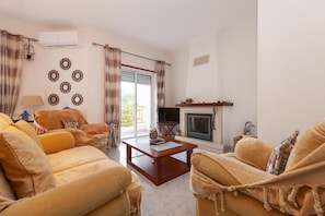 A living room with a sofa set, a coffee table, a fireplace, and decorative wall art.