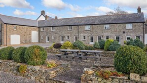 A stone building with multiple windows, a covered patio, and a picnic table. - 3 Bed Cottage • Parking • Ideal for Work Trips (Pontardawe)