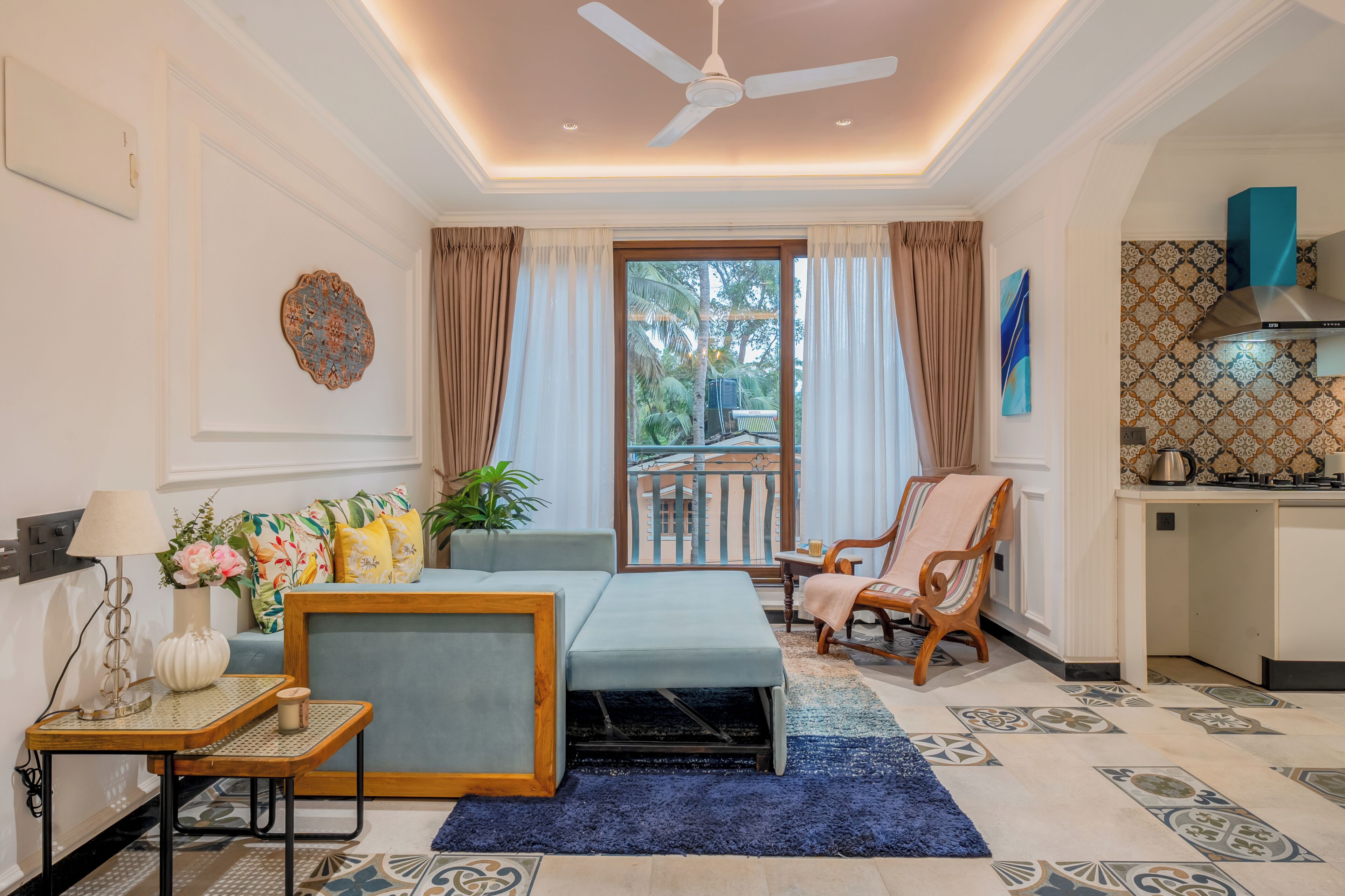A room with a ceiling fan, a sofa, a chair, a small table, and a view through a glass door to an outdoor area.