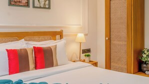 Hotelkamer met een bed, nachtkastje met een lamp, wandairconditioning en een deur met een geweven paneel.