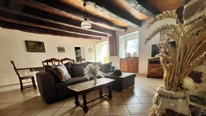 Un salon comprenant un canapé, une table basse, un fauteuil et un vase décoratif.