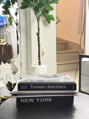 Ein Buch mit dem Titel 'Toronto Interiors' auf einem Tisch zusammen mit einer Topfpflanze und einem kleinen Dekoelement.