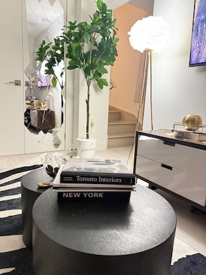 Ein modernes Interieur mit einem Blumentopf, einem Bücherstapel, einer Lampe und einem schlichten Schreibtisch.