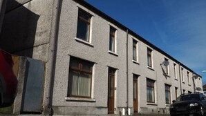 A two-story building with a flat facade, multiple windows, and a parked car. - 4 Bed • Parking • Near M4 • Ideal for Workers (Aberavon)