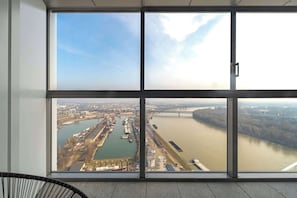 A large window with a view of a river and industrial area. - Eurovea Luxus & Comfort (Bratislava)