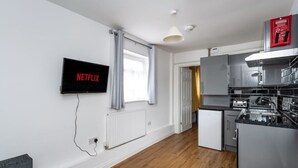 A modern kitchen with a built-in oven, a refrigerator, and a microwave.