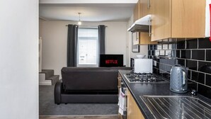 A compact kitchen with a gas stove, a kettle, and a microwave. - King•En-suite Flat•Kitchen•Quiet Near Shops & Bus (Swansea)