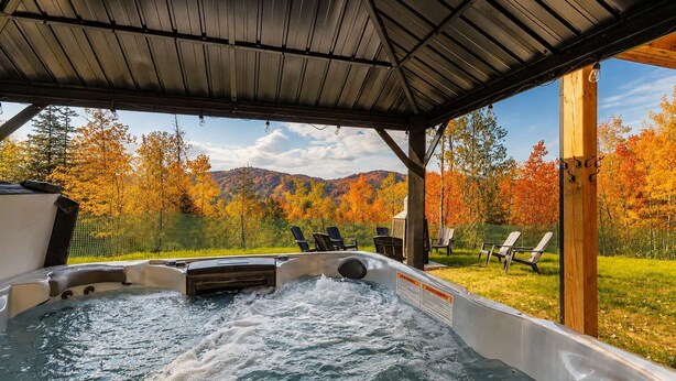 Ein Whirlpool mit Blick auf Herbstbäume und Berge.