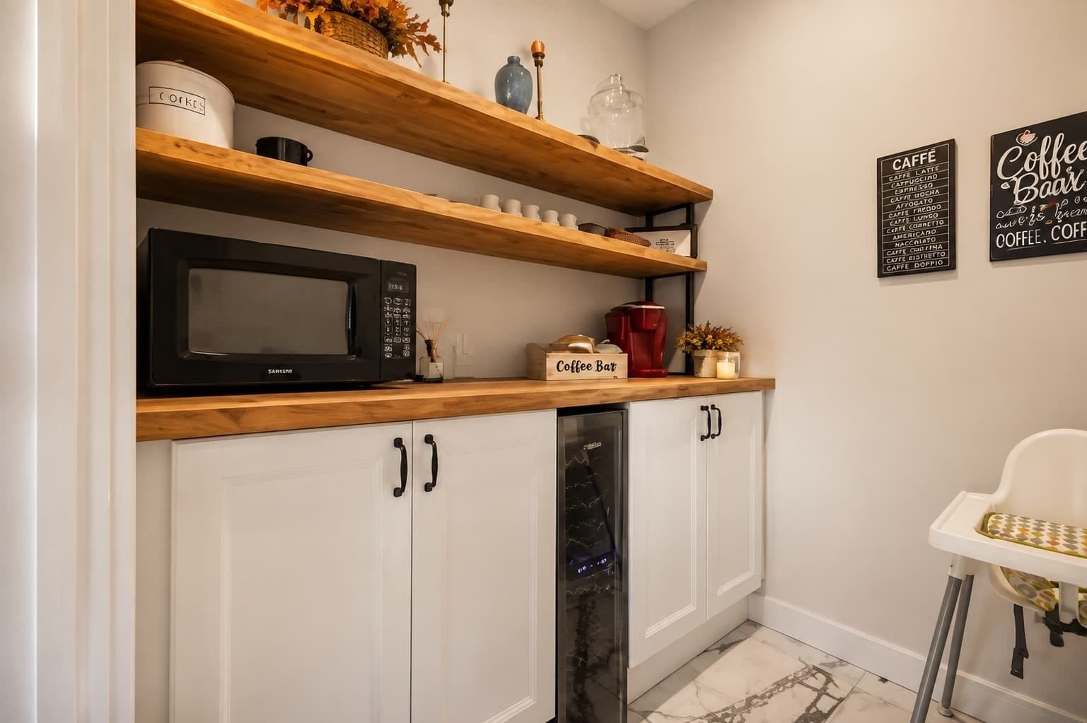 A kitchen with a microwave, coffee bar, and a refrigerator.