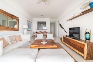 A modern living room with a sofa, coffee table, TV, and a dining area with chairs and a table. - ®{3BR~Hemingway~Retreat}@JuanDolio+WalktoBeach+GYM (Juan Dolio)