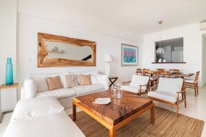 A modern living room with a sofa, coffee table, and dining area. - ®{3BR~Hemingway~Retreat}@JuanDolio+WalktoBeach+GYM (Juan Dolio)